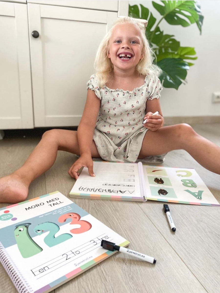 Jente som bruker en bokpakke fra Sjarmtroll med tall og bokstaver