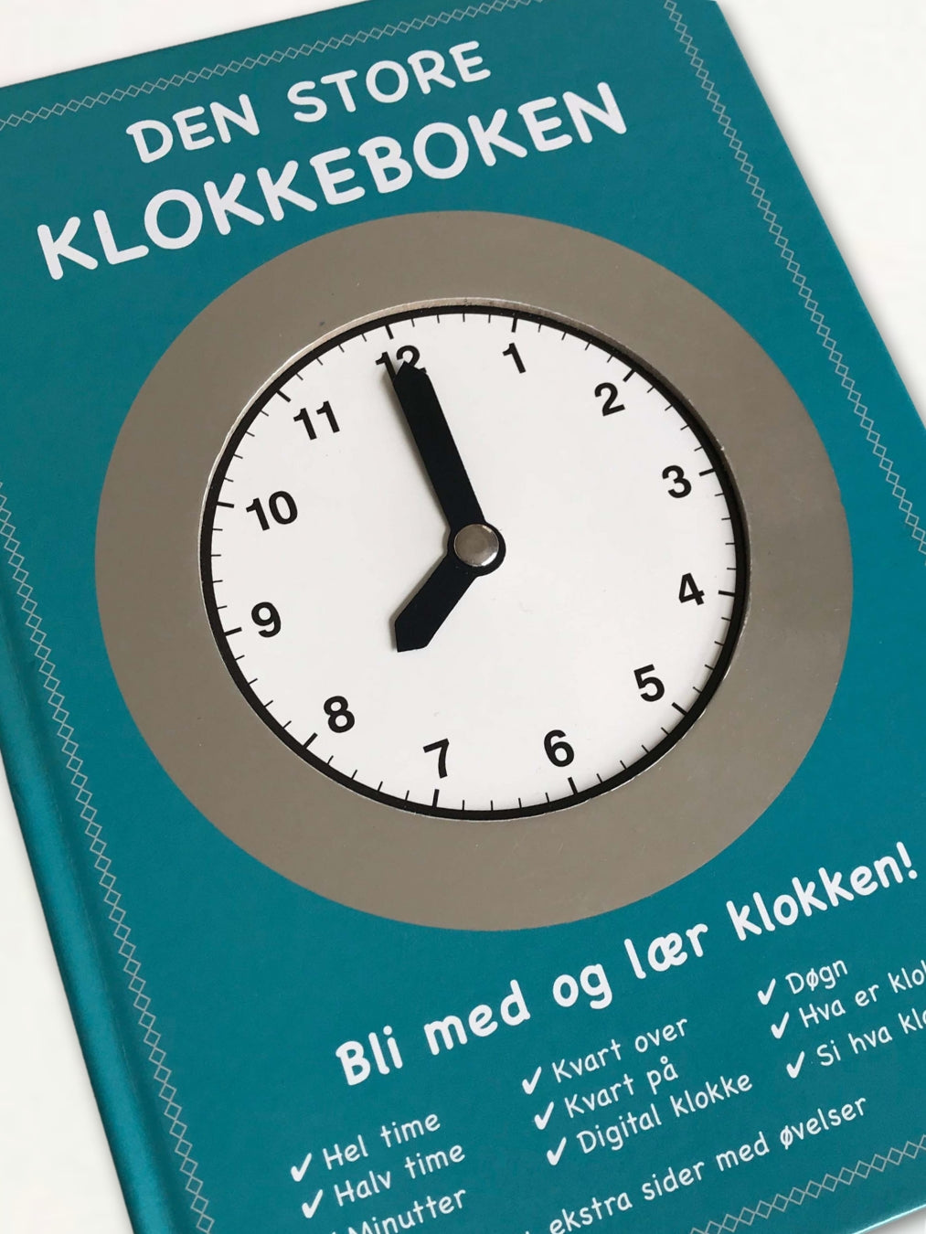 Nærbilde av en klokkebok fra Sjarmtroll.no. Lær klokken.