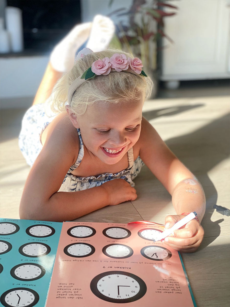 En jente som øver på klokken. Enkelt å lære klokken.