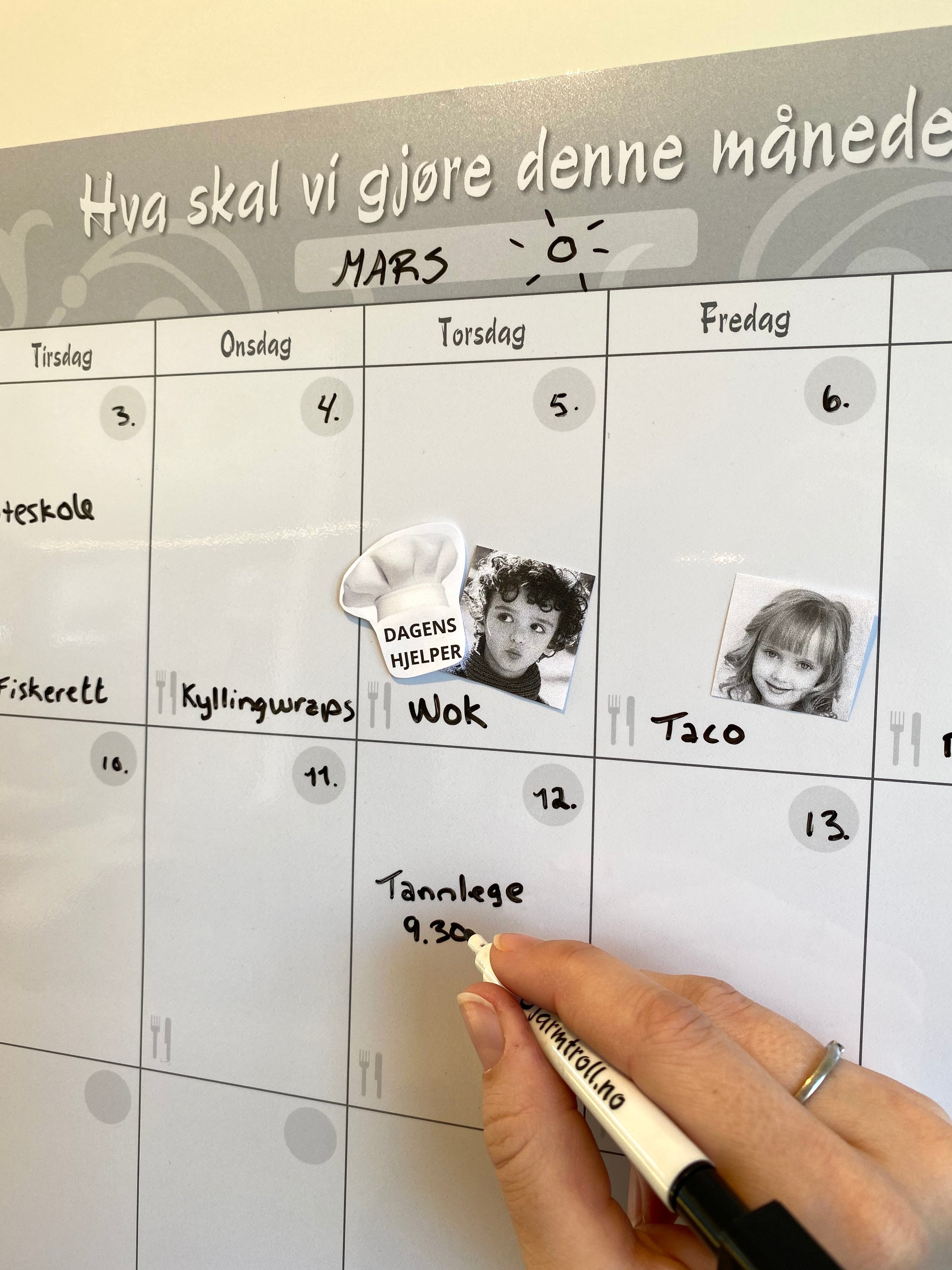 En mor som fyller ut månedens avtaler på en familiekalender.