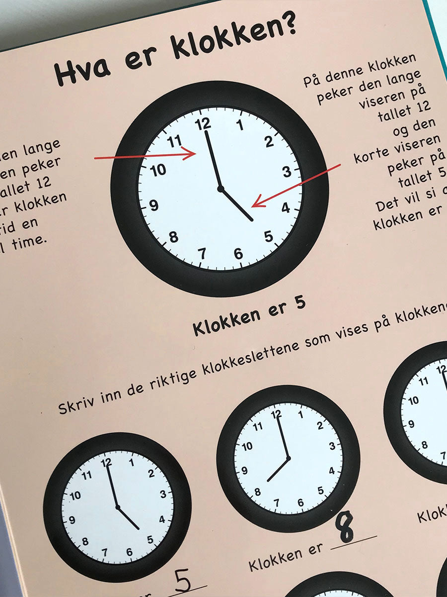 Nærbilde av en side i klokkeboken. Hva er klokken? Hvordan enkelt lære barn klokken. Et hjelpemiddel i læringen av klokken.