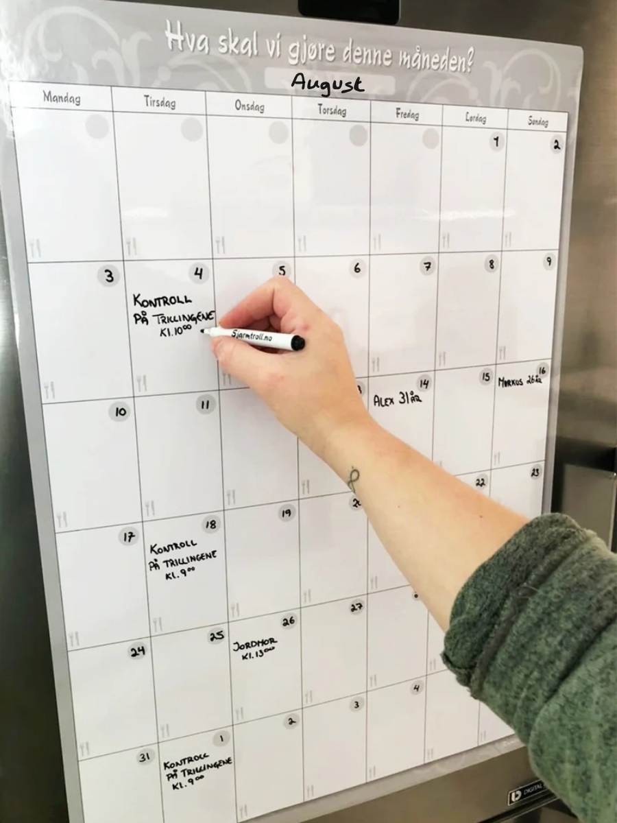 Månedsplan som henger magnetisk på kjøleskapet. Planer skrives på med whiteboardtusj.