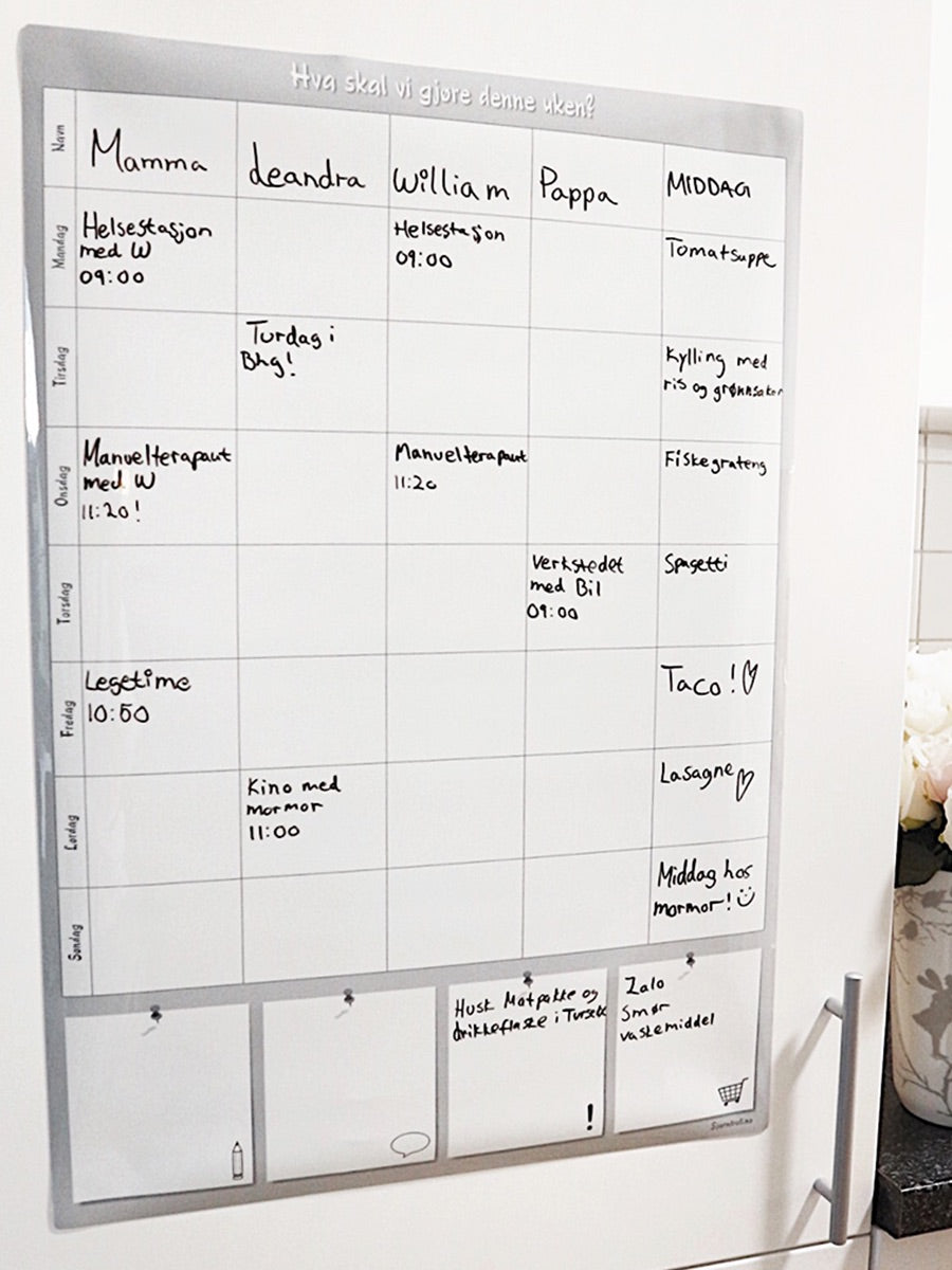 Ukeplanlegger som henger på et integrert kjøleskap.