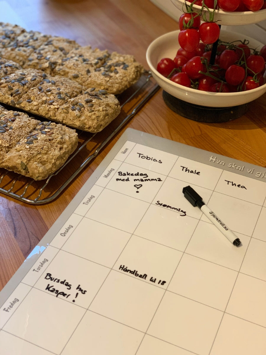Nærbilde av en ukeplan på kjøkkenet.