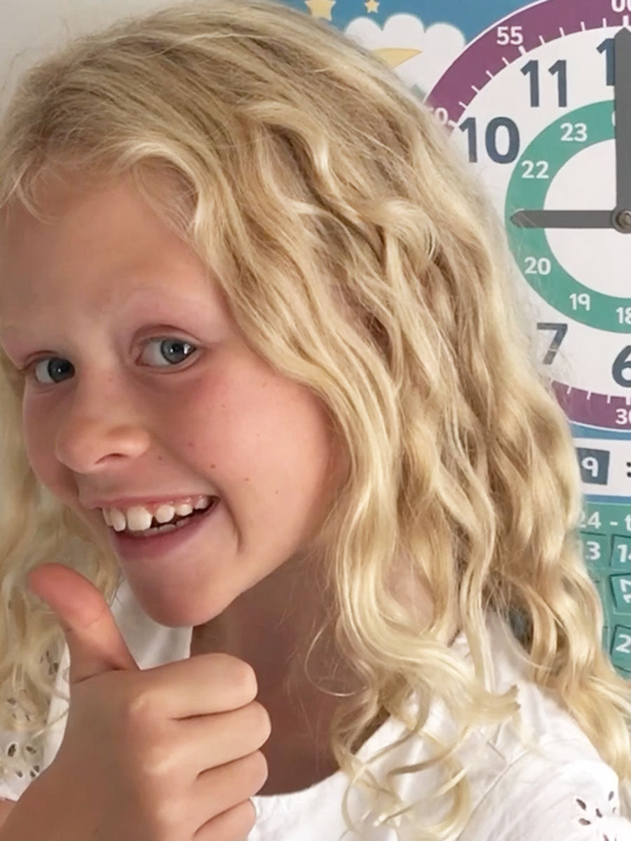 En jente som øver på klokken. Barnet lærer både analog og digital klokke.